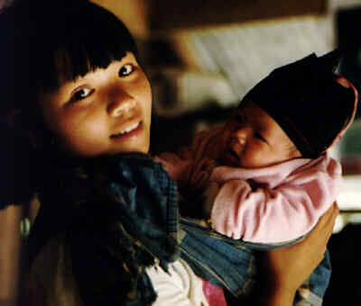 Appa, an Akha girl from Burma, with her baby